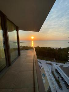 米兹多洛杰Wave De Luxe Studio Resort&SPA 755B - Sea View的从大楼的阳台上可欣赏到日落美景
