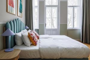 布拉格numa I Flow Rooms & Apartments的卧室配有带枕头的大型白色床