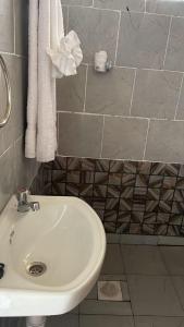 KaratinaTHE PLANTAINS PLACE的浴室配有白色水槽和毛巾