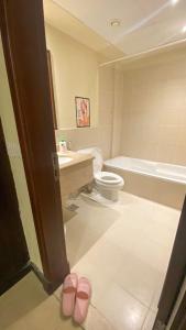 阿卜杜勒国王经济城شقق نسيم البحر的浴室设有卫生间、水槽和2个粉红色的拖鞋。