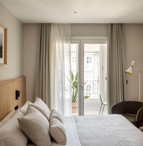 维多利亚-加斯特伊兹NIREA HOTEL的一间卧室设有一张床和一个滑动玻璃门