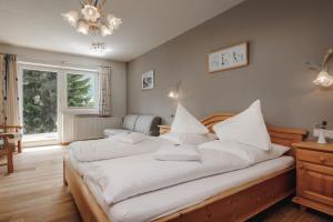 贝旺罗特乐切霍夫酒店的一间卧室配有两张带白色床单和吊灯的床。