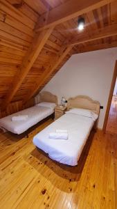 陶尔Boí Taüll CALMA DÚPLEX的配有木天花板的客房内的两张床
