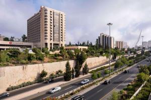 耶路撒冷耶路撒冷华美达酒店的城市里汽车驶向高速公路,有建筑