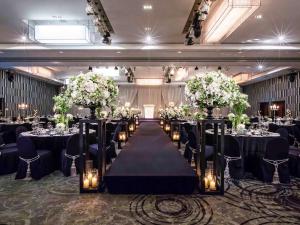 首尔首尔江南大使诺富特酒店的宴会厅设有长桌子,摆放着鲜花和蜡烛