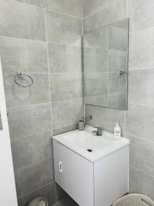 哈博罗内Zanaya Apartments的浴室设有白色水槽和镜子