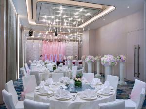 新加坡Mercure Singapore Bugis的宴会厅配有白色的桌子和白色的椅子