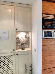 特雷维索圣莱昂纳多拉蒂娜套房公寓的厨房配有带微波炉的白色橱柜