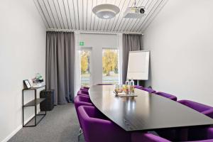哈尔姆斯塔德Tyleback Hotell; Sure Hotel Collection by Best Western的一间会议室,配有紫色椅子、一张桌子和一个窗户