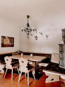 ArriachGasthof Arriach的一间带桌椅和吊灯的用餐室