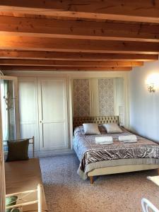 特雷维索圣莱昂纳多拉蒂娜套房公寓的一间卧室设有一张床和木制天花板