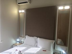 德班The Travel Inn Durban的卧室配有白色的床和大镜子