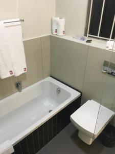 德班The Travel Inn Durban的带浴缸和卫生间的浴室。