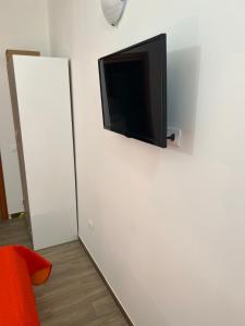 科森扎B&B l’antico rudere 2的挂在白色墙壁上的平面电视