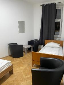 维也纳easybook-in的一间设有两张床和两把椅子及桌子的房间