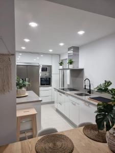 塔里法Apartamento Balneario Beach的厨房配有白色家电和木桌