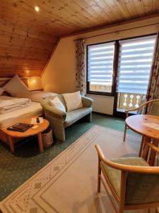 托特瑙Hotel Obergfell的酒店客房配有床、沙发和桌子。