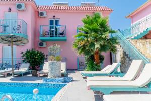 拉加纳斯Maui的粉红色的房子,配有躺椅和游泳池