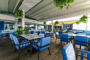 梅利哈db Seabank Resort + Spa All Inclusive的一间配备有蓝色椅子和桌子的用餐室