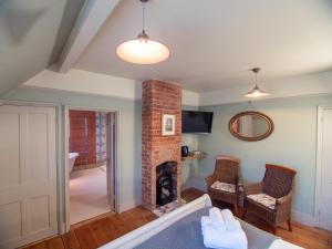 拉伊Red Cottage B&B的客厅设有砖砌壁炉和椅子