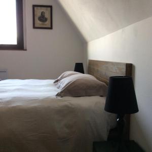 勒克罗图瓦La VILLA en BAIE的一间卧室配有一张带两盏灯的床和一扇窗户。