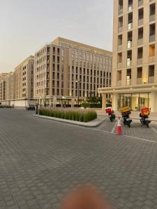 沙迦luxury 1 BR studio in Sharjah的停放在停车场的摩托车大建筑