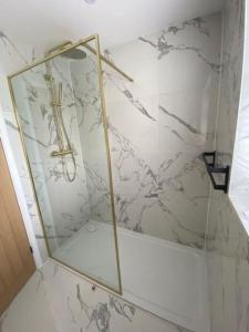 SaltfordThe Annex, Bath Road, Saltford的浴室设有玻璃淋浴间,墙上有十字架