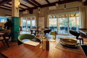 塞尼Veladrion Adults Exclusive Boutique Resort的一间带桌椅的用餐室和一间带窗户的房间