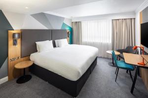 南安普敦假日南安普敦伊斯特利酒店的配有一张床和一张书桌的酒店客房