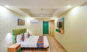 新德里FabHotel Aerosky Grand的一间带大床和电视的卧室