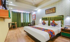 新德里FabHotel Aerosky Grand的酒店客房设有一张大床和一张书桌。