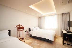 釜山Hotel Hongdan的酒店客房配有两张床和一张书桌