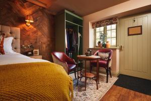 布兰斯科姆梅森阿莫斯酒店的卧室配有一张床和一张桌子及椅子