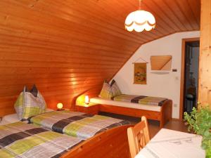 皮恩山口附近施皮塔尔Familienbauernhof Imitz, Ferienwohnung的木墙客房的两张床