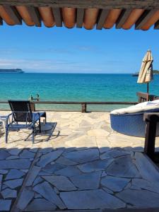 布希奥斯贝拉-艾米利亚度假屋的一个带椅子和遮阳伞的庭院和大海