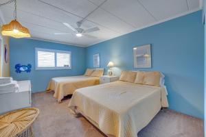 大洋城Salty Sands的一间卧室设有两张床和蓝色的墙壁
