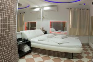 桑托斯Studio Motel (Adult Only)的卧室配有白色的床和镜子