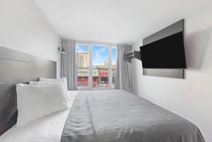 布朗克斯Hotel TREMONT Bronx Yankee Stadium的一间卧室设有一张大床和一台平面电视。