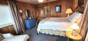 安吉利斯港PA Crows Nest Cottage的一间卧室配有一张床和一张带台灯的桌子