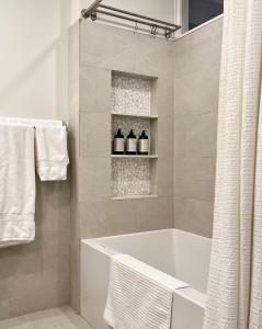 布鲁克林Close to all! 2-room suite in a 1-family townhouse的白色的浴室设有浴缸和毛巾。