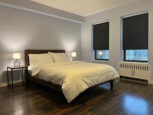布鲁克林Close to all! 2-room suite in a 1-family townhouse的一间卧室设有一张大床和两个窗户。