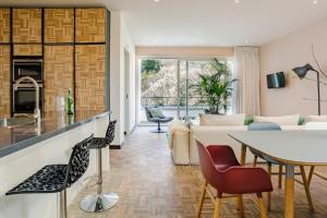 布罗门代尔Bloemendaal Hotel Collection Apartments的厨房以及带桌椅的起居室。