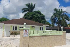 拿骚Budget & Basic in Local Neighborhood, 7min Drive to Downtown Nassau Beach Paradise的房屋前有栅栏和标志