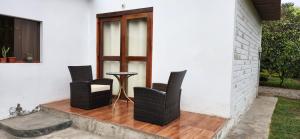 利马Fundo Don Ricardo的门廊上的三把椅子和一张桌子