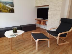贝尔恩卡斯特尔-库斯Ferienhaus Moselglück - kostenlose ÖPNV-Nutzung inbegriffen的客厅配有沙发、桌子和椅子