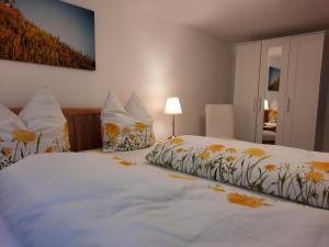 贝尔恩卡斯特尔-库斯Ferienhaus Moselglück - kostenlose ÖPNV-Nutzung inbegriffen的卧室配有一张白色的大床,并拥有黄色的鲜花