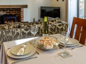 布伦特山庄East Cottage - Ukc4432的一张桌子,上面放着一瓶葡萄酒和一碗食物