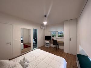 地拉那Grand Park & Bllok Area Rooms的卧室配有一张白色大床和一张书桌