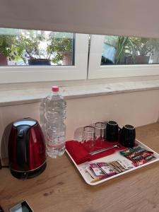 地拉那Grand Park & Bllok Area Rooms的桌子上摆放着一瓶水,带眼镜