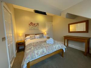 凯西克Wordsworth House的一间卧室配有床、两张桌子和镜子
